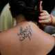 This tattoo translates to “Revolution is a woman” (Image: AP)